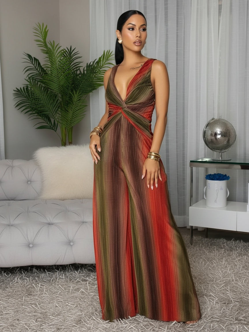 Woman in a colorful dress standing in an indoor setting with a couch and decorative items.