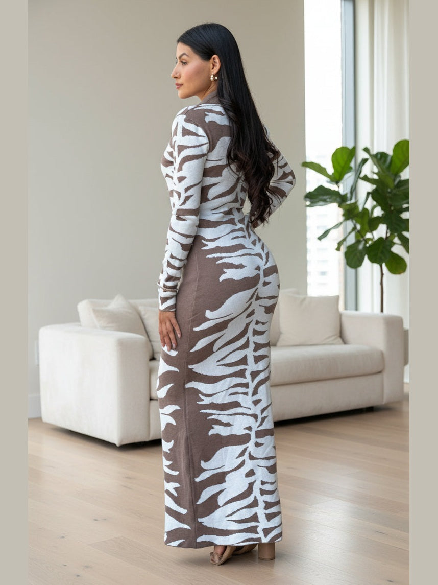 Woman wearing a long, patterned dress in a living room setting.