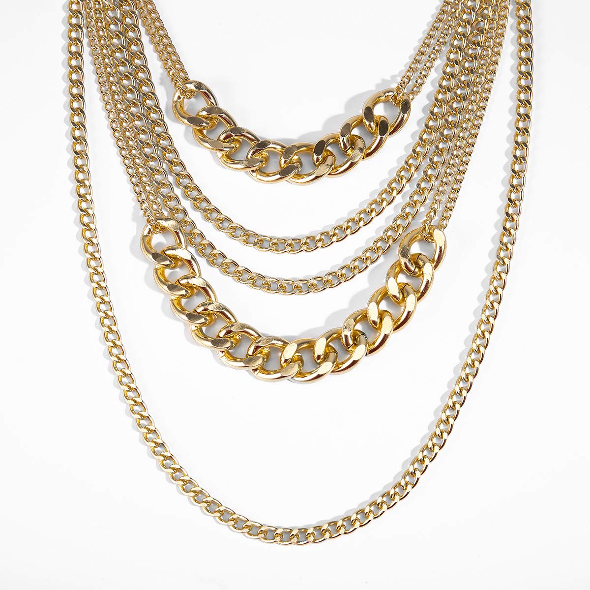Stack of gold chain necklaces on a white background