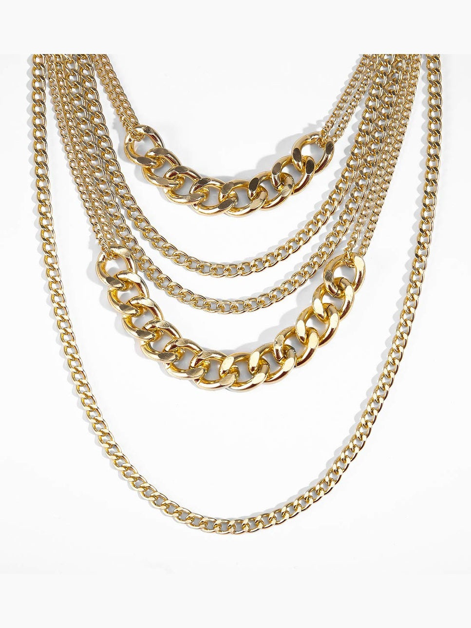 Stack of gold chain necklaces on a white background