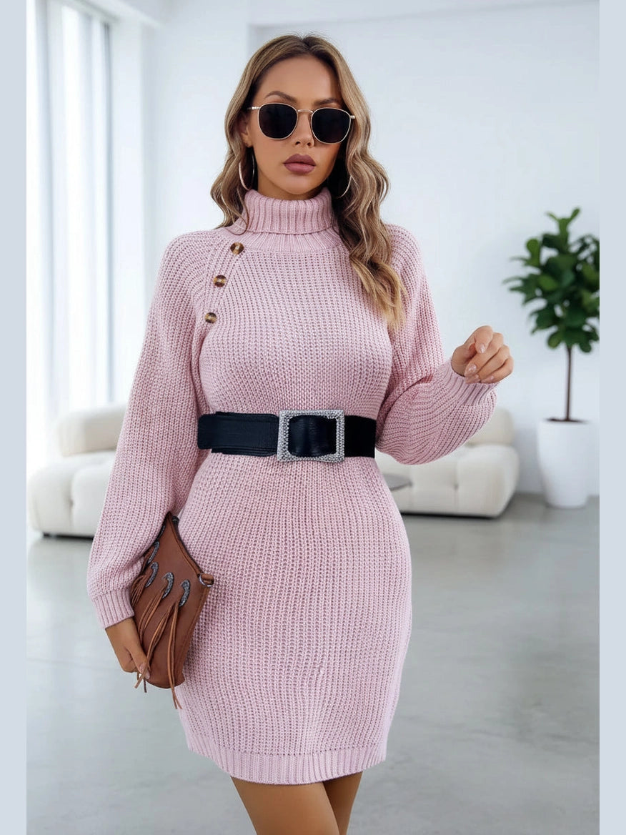 Woman wearing a pink knitted dress with a black belt against a white background