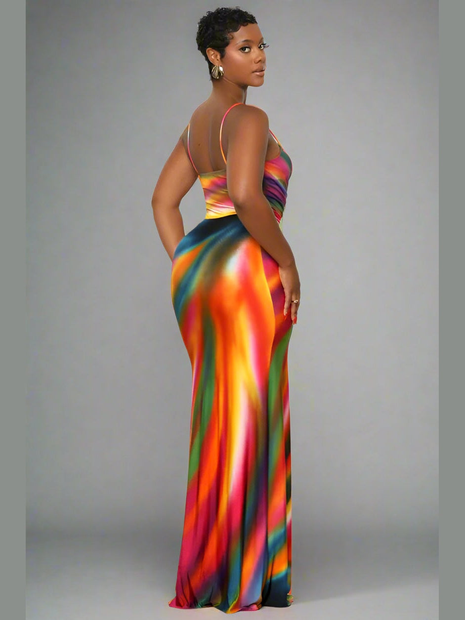 Model wearing a sleeveless multicolor maxi dress with thin straps, a V-neckline, and a flowy, draped skirt — perfect for summer or casual occasions