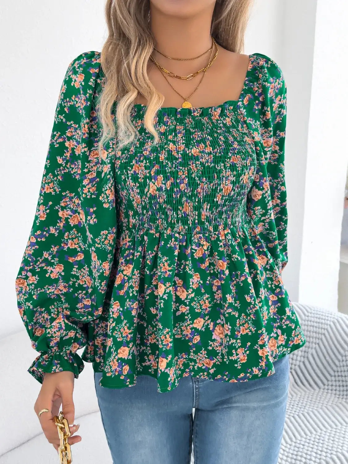 Off-shoulder floral blouse with a vibrant floral pattern, elastic neckline, and flowy sleeves, perfect for a feminine and effortless look facing forward in green