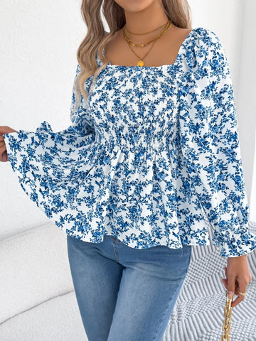 Off-shoulder floral blouse with a vibrant floral pattern, elastic neckline, and flowy sleeves, perfect for a feminine and effortless look in blue. 