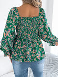 Off-shoulder floral blouse with a vibrant floral pattern, elastic neckline, and flowy sleeves, perfect for a feminine and effortless look in green facing backward
