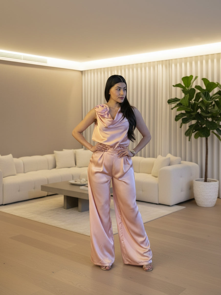 Woman in a pink outfit standing outdoors with decorative lights in the background