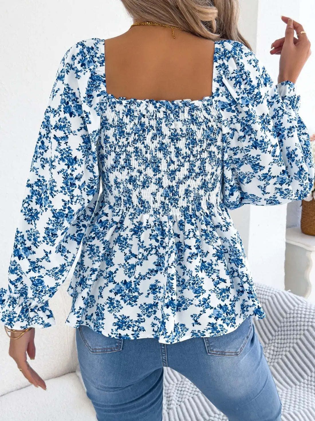 Off-shoulder floral blouse with a vibrant floral pattern, elastic neckline, and flowy sleeves, perfect for a feminine and effortless look in blue. 