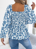 Off-shoulder floral blouse with a vibrant floral pattern, elastic neckline, and flowy sleeves, perfect for a feminine and effortless look in blue facing backward.