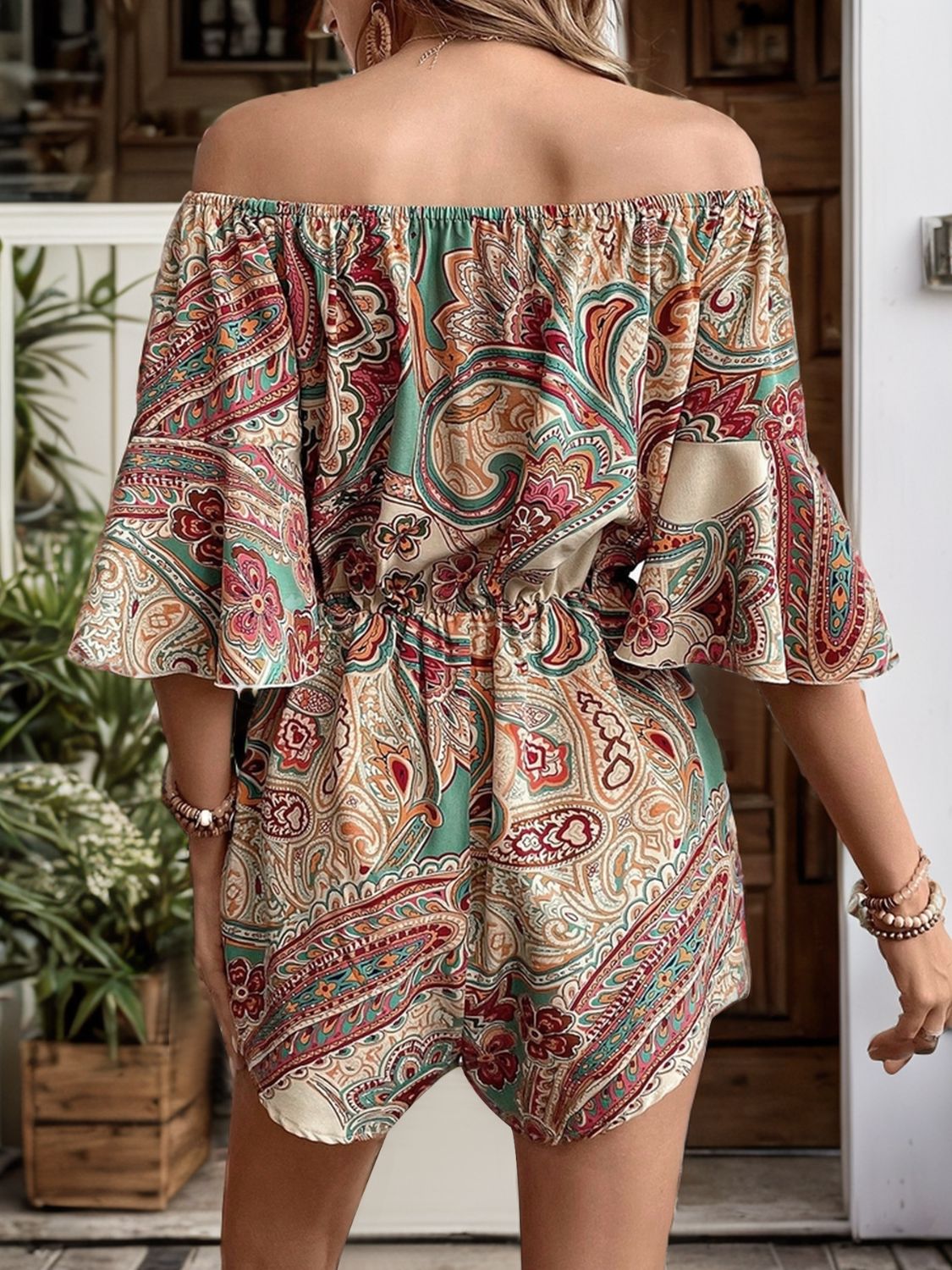 Back view of the floral printed off-shoulder romper showing ruffled sleeves and fitted waist